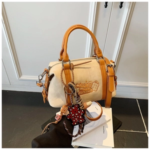 Detail der cremefarbenen Boston Bag mit Bärenstickerei und Leoparden-Anhänger