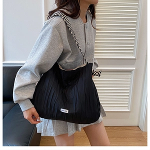 Détail d'un sac cabas plissé noir avec bandoulière large à motif zèbre élégant