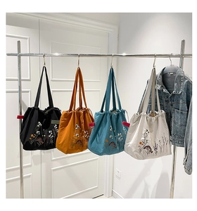 Detail of four colorful vintage tote bags with floral embroidery and drawstring closure