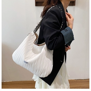 Détail du grand sac cabas plissé blanc avec sa bandoulière tissée à rayures noir et blanc