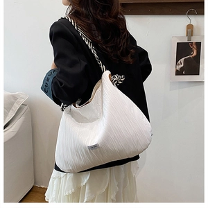 Détail du sac cabas matelassé blanc avec bandoulières élégantes en corde zébrée