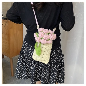 Detail of handmade crochet phone bag with 3D pink roses and soft cotton weave texture