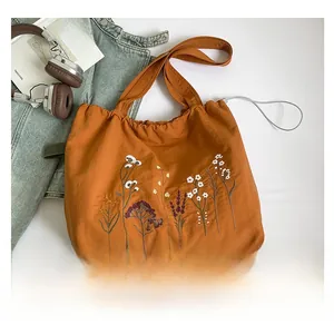 Close-up of caramel embroidery tote bag with floral patterns and drawstring closure