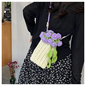 Detail of handmade knit mini bag featuring 3D purple floral crochet and cream texture