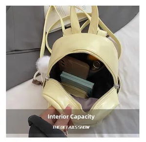 Internal capacity of mini yellow backpack showing phone and wallet storage