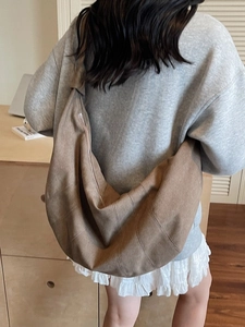 Brown canvas dumpling crossbody bag with half-moon shape and shoulder strap