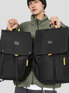 Large black canvas backpack for travel with yellow contrast straps and flap closure