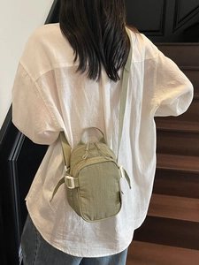 Light green nylon crossbody bag with adjustable strap and side buckle for casual outdoor use