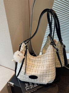 Chic beige tweed hobo bag with black adjustable strap and plush charm for women