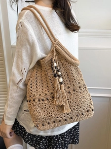Handcrafted woven tote bag with fringe tassels and wooden beads for summer leisure