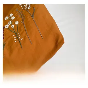 Close-up of floral embroidery on a vintage brown tote bag with high-quality fabric texture