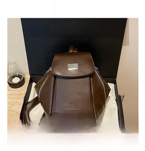 Detail shot of a dark coffee brown multi-pocket faux leather backpack inside a premium gift box