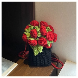 Detail of handcrafted crochet bucket bag with red 3D roses and woven drawstring strap