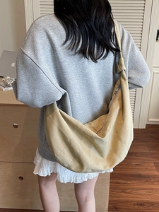 Large beige suede canvas dumpling bag for women shown as a minimalist shoulder bag