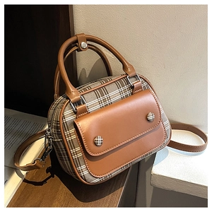 Detailansicht des braunen Lederriemens und Karomusters auf einer quadratischen Handtasche