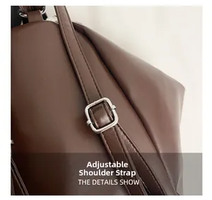 Detail view of adjustable dark brown leather shoulder strap with silver square metal buckle
