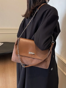 Retro brown leather chain bag worn by a model against a minimalist interior background