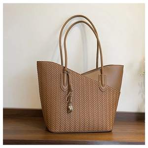 Detail of vintage brown tote bag with herringbone weave and leather splicing detail