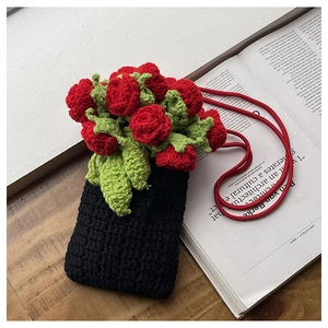 Detailed close-up showing the intricate crochet texture and 3D floral accent of the phone bag