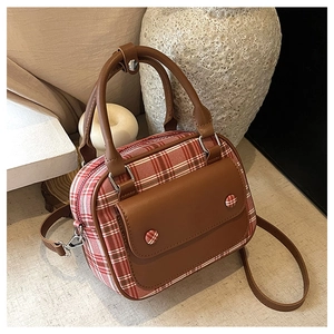 Detail der rot-weiß karierten Boston Bag mit braunen Ledergriffen und Schultergurt