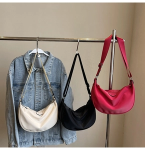 Three nylon crescent bags in white, black, and pink with adjustable shoulder straps
