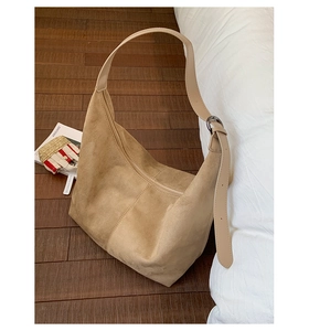 Detailed view of camel suede hobo bag featuring adjustable strap and metallic buckle