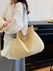Sac fourre-tout plissé jaune clair avec bandoulière tressée rayée vue de profil latérale