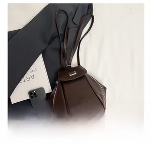 Close-up of brown leather multi-pocket backpack with metal zippers and brand logo