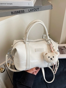 Creamy white PU leather pillow bag with plush bear charm and adjustable shoulder strap