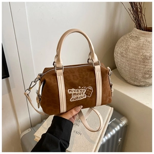 Detaillierte Stickerei mit Keks-Motiv und Text auf brauner Wildleder-Boston-Handtasche