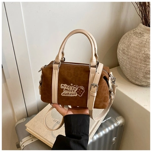 Details einer braunen Boston-Tasche aus Wildleder mit Keks-Stickerei und Griffen