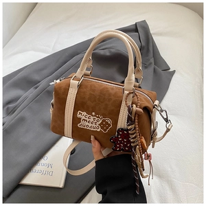 Detailansicht der braunen Boston-Tasche mit Bären-Patches und Leoparden-Anhängern