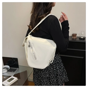 Detail of off-white leather shoulder bag featuring silver diagonal zipper decoration