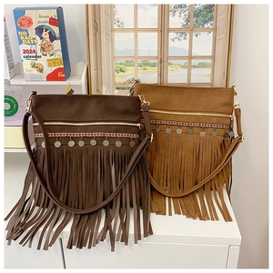 Détail du sac bandoulière bohème à franges avec sangles ethniques et pendentifs
