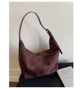 Close-up of the adjustable strap and suede texture on a dark brown hobo shoulder bag