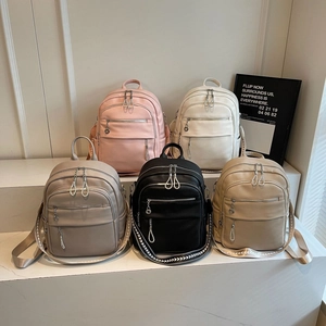 Five assorted colors of textured faux leather backpacks with stylish woven straps