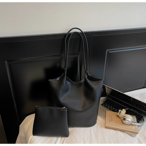 Close-up of black lychee grain leather tote bag set with matching zip pouch