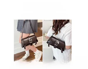 Detail of dark brown leather shoulder bag with vintage silver buckle and side zipper