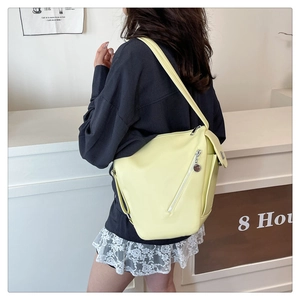 Detail of trendy lemon yellow leather backpack with stylish diagonal zipper and metal ring