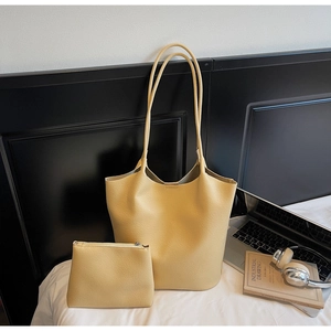 Detailed view of yellow lychee grain leather tote bag set with a matching small pouch