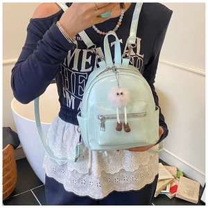 Mint green mini PU leather backpack featuring a white plush pompom charm and side pockets