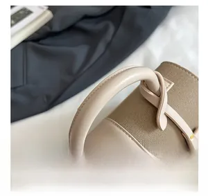 Détail rapproché du sac à main bicolore beige et marron avec fermoirs dorés élégants