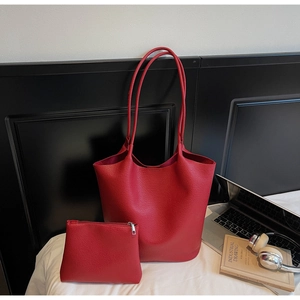 Close-up of red lychee grain leather tote bag with matching zipper pouch set