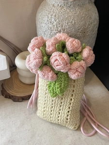 Handmade crochet floral crossbody bag with pink flowers and a beige knit texture