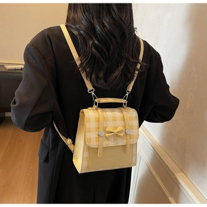Detail of yellow plaid backpack with bow decoration and adjustable shoulder straps