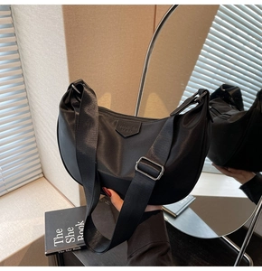 Detail of black nylon crescent bag with wide strap and silver metal buckle adjustment
