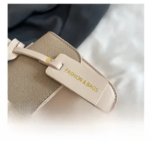 Gros plan du tissu tissé beige avec coutures en cuir et étiquette à rivets dorés