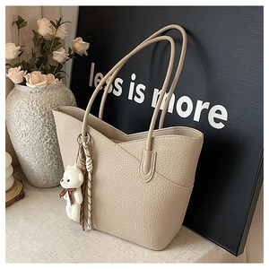 Detailansicht beige Tote Bag mit Litchi-Struktur und Plüschbär-Anhänger Accessoire