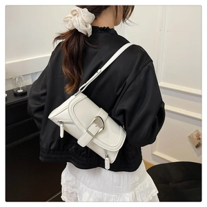 Detail of white patent leather shoulder bag with oversized silver buckle and zipper texture