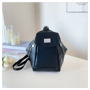 Detail of black PU leather backpack with silver metal plate and side zippers
